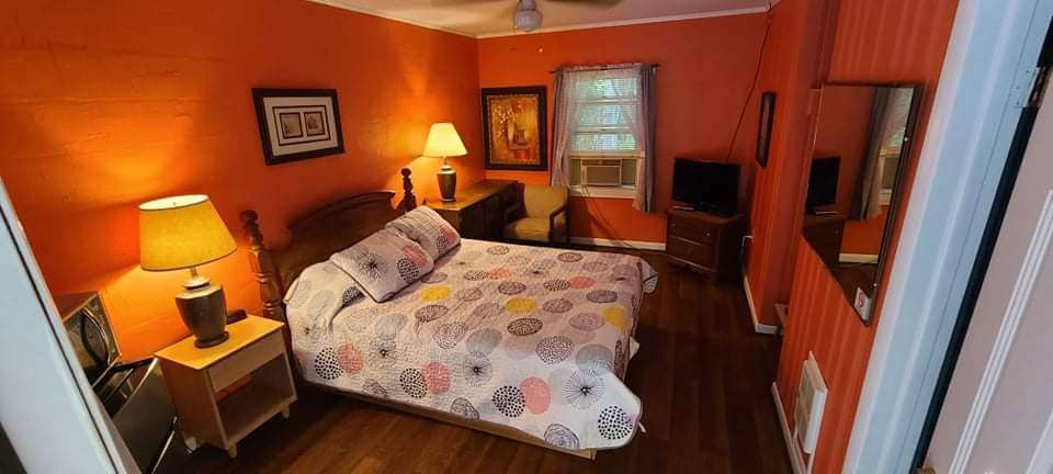 Warm orange guest room with floral bedspread