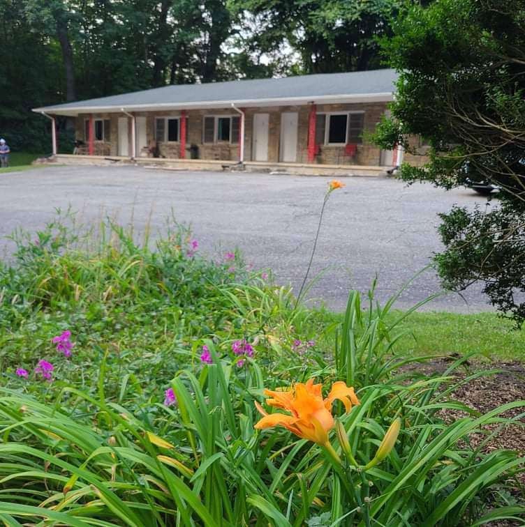 Motel building with orange doors and parking lot