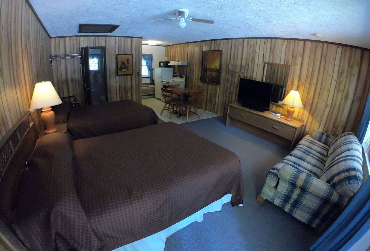 Two beds with plaid blankets and television