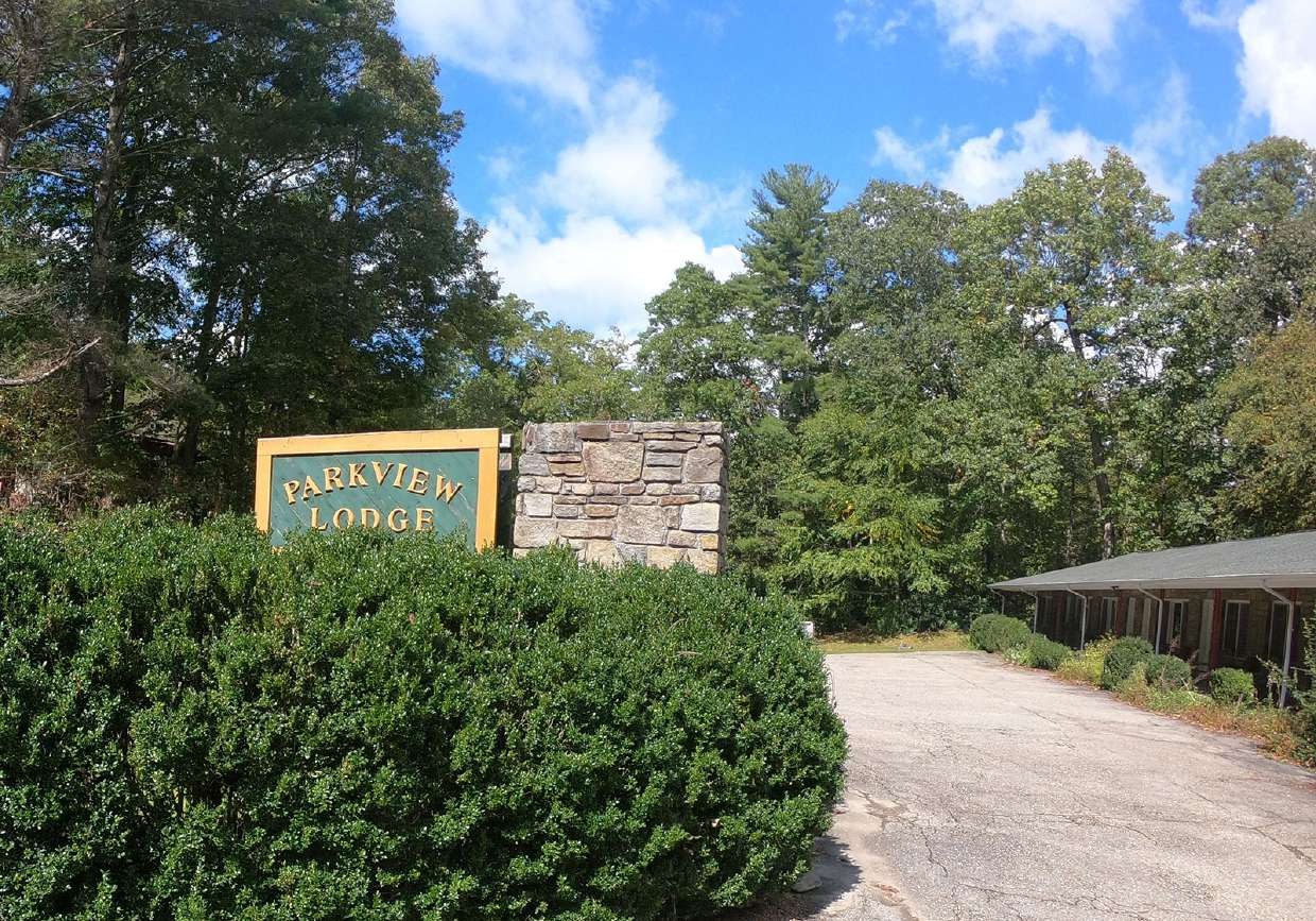 Entrance sign beside the hedge and driveway
