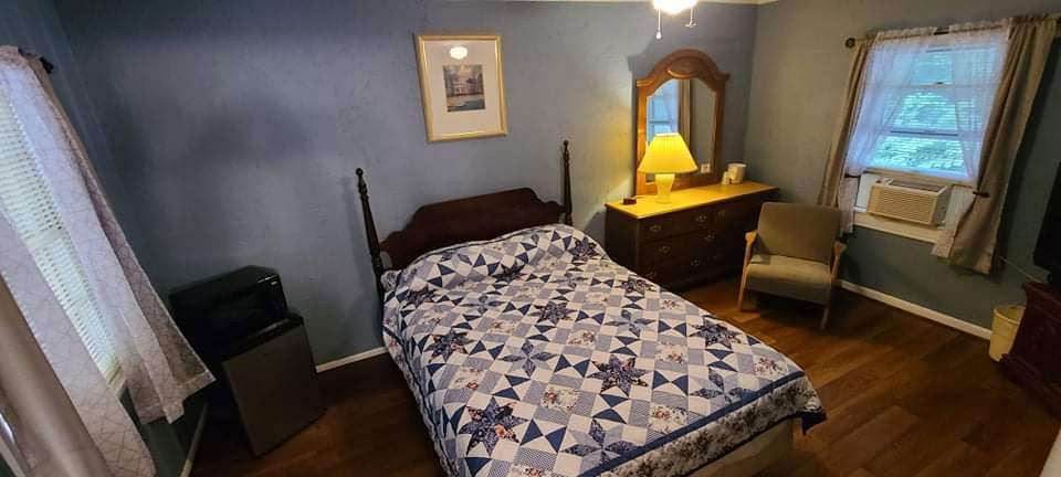 Blue guest room with patchwork quilt and dresser mirror