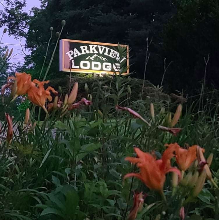 Parkview Lodge sign among daylilies at dusk