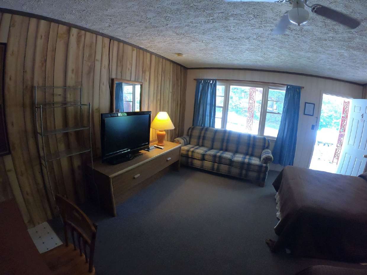 Wood-paneled living area with sofa and curtains